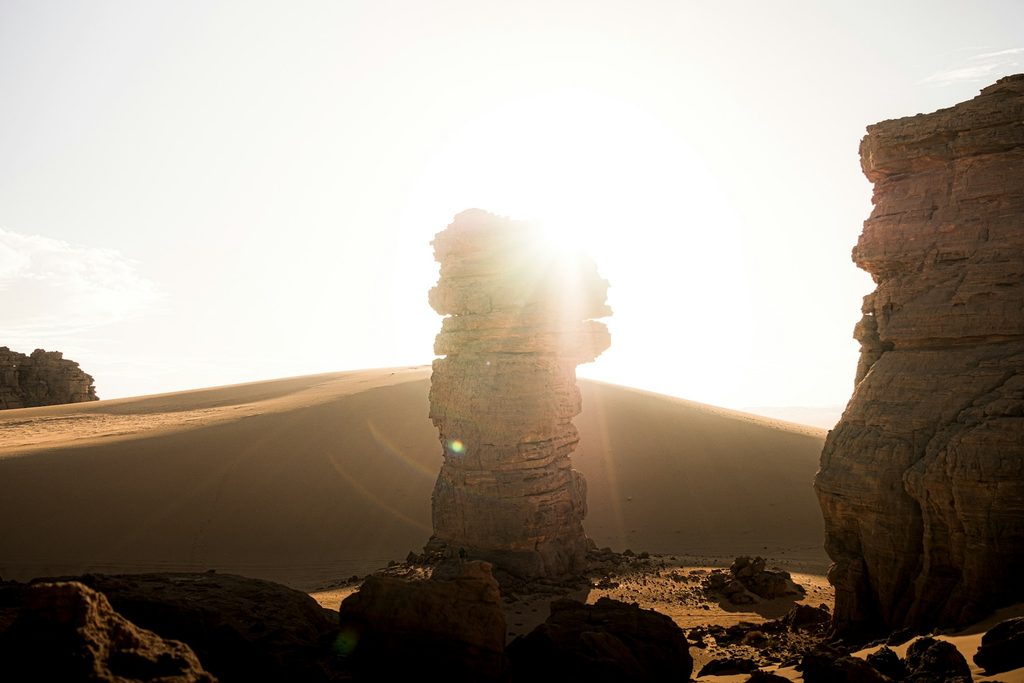 Sunlight breaking through sandstone rock formations in the desert near Djanet, Algeria